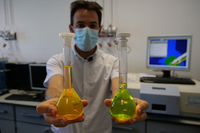 Un investigador sujetando sustancias orgánicas inocuas fluorescentes usadas como técnicas de ensayo para simular la trayectoria que toma un contaminante