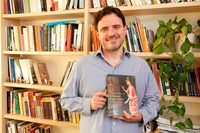 El investigador Antonio Calvo posa con uno de sus libros en su despacho de la Facultad de Filosofía y Letras 