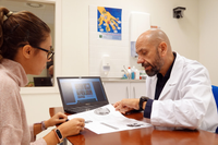 El investigador José Miguel Morales con una paciente en un laboratorio de la Facultad de Ciencias de la Salud